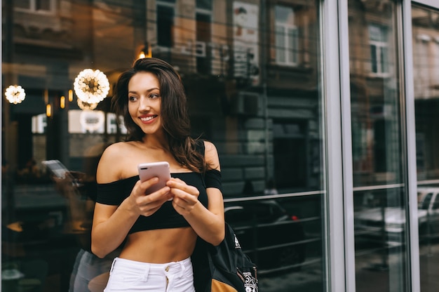 hermosa chica con telefono en la ciudad