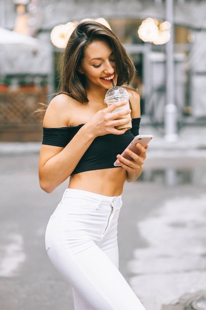 hermosa chica con telefono en la ciudad