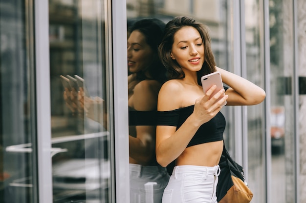 hermosa chica con telefono en la ciudad