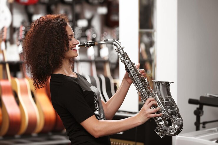 Foto hermosa chica tocando el saxofón en la tienda de música