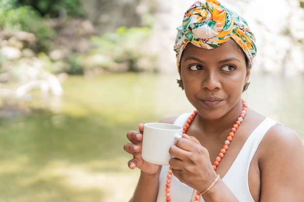 Hermosa chica tomando café en el bosque