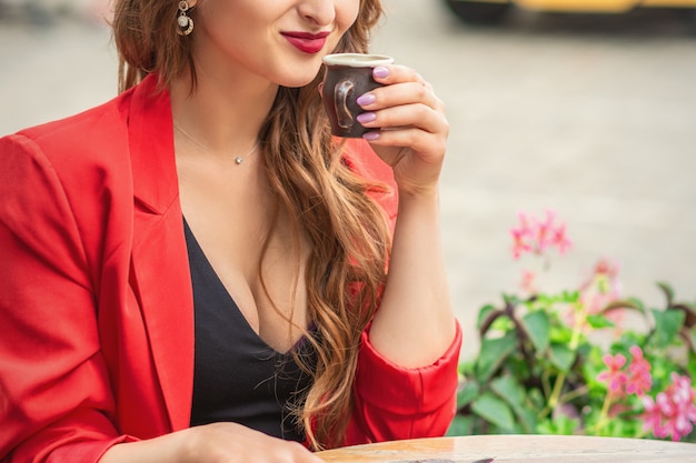 Hermosa chica tomando un café en el café al aire libre.