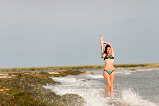 Hermosa chica tomando el sol y nadando en el mar