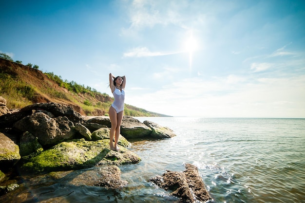 Hermosa chica tomando el sol y nadando en el mar