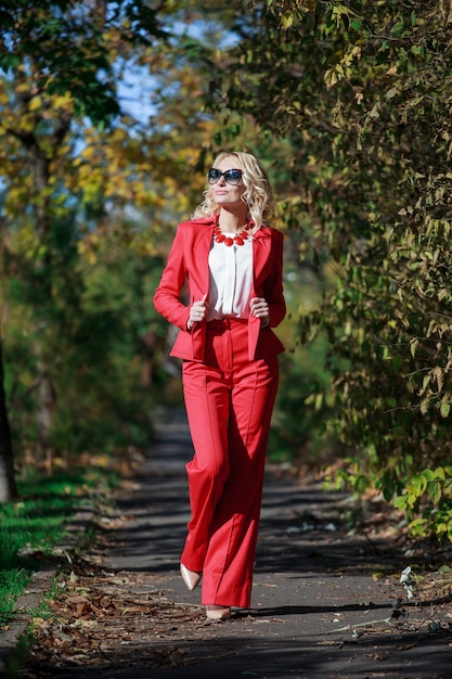 Hermosa chica en un traje rojo en otoño