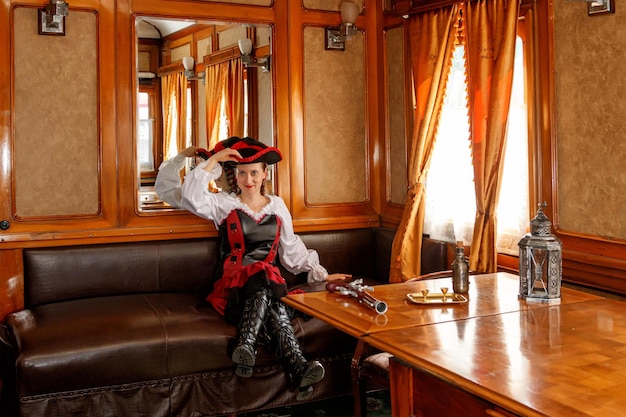 Hermosa chica en traje steampunk en un viejo vagón de tren
