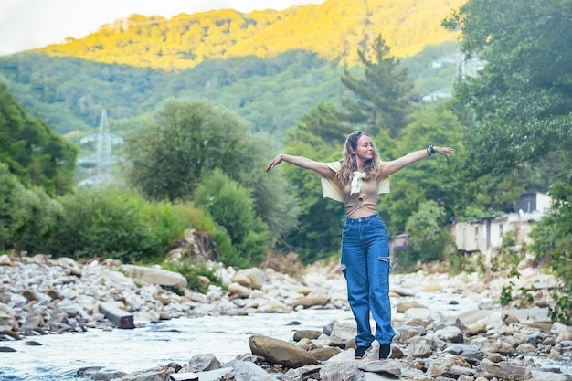 hermosa chica turista cerca de un río de montaña en un paseo