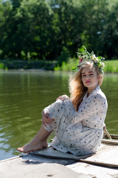 Hermosa chica ucraniana se sienta junto al río