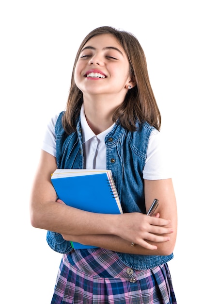 Foto hermosa chica en uniforme escolar con un cuaderno en la mano sobre un fondo blanco