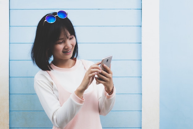 hermosa chica usando teléfono móvil en el tiempo libre con feliz