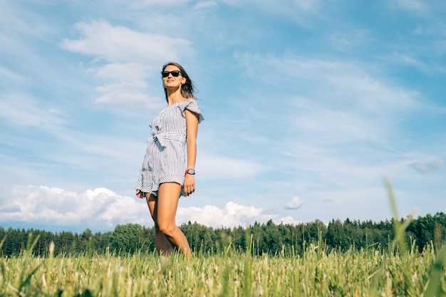 Hermosa chica vestida en campo verde. Concepto de personas y naturaleza