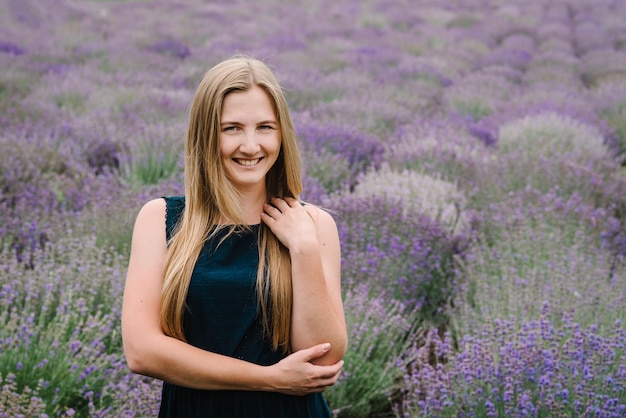 Hermosa chica vestida de pie en el campo de lavanda púrpura Hermosa mujer camina en el campo de lavanda al atardecer en Francia Enfoque suave Disfruta en el claro floral verano naturaleza Cara de cerca