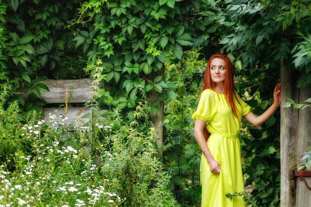 Hermosa chica con vestido amarillo cerca de la puerta