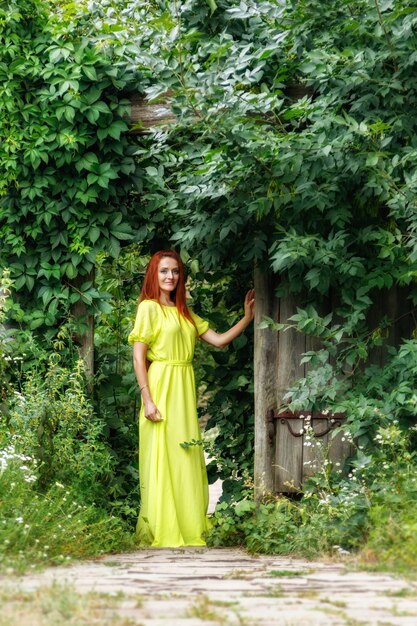 Hermosa chica con vestido amarillo cerca de la puerta