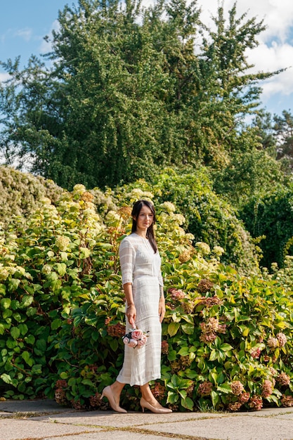 Hermosa chica con un vestido blanco en el parque