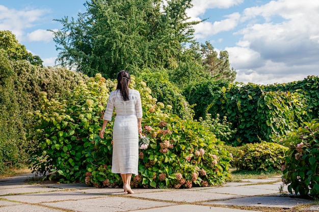 Hermosa chica con un vestido blanco en el parque