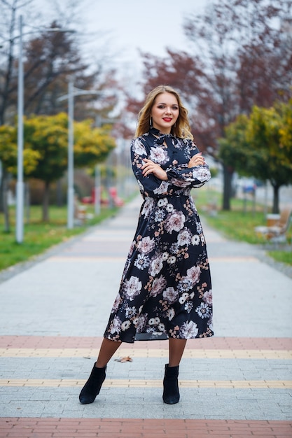 Hermosa chica con un vestido en un callejón de la ciudad