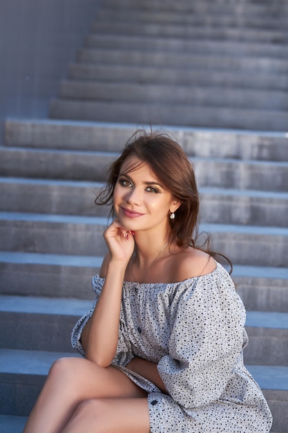 Hermosa chica en vestido elegante y encantadora sonrisa