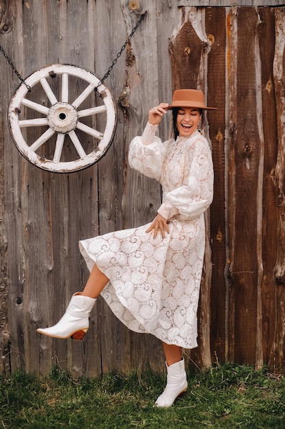 Hermosa chica con vestido de encaje vintage y sombrero en el rancho