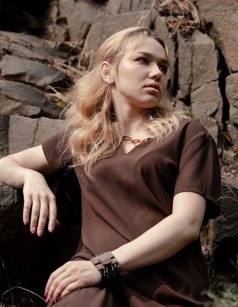 La hermosa chica con un vestido en las rocas