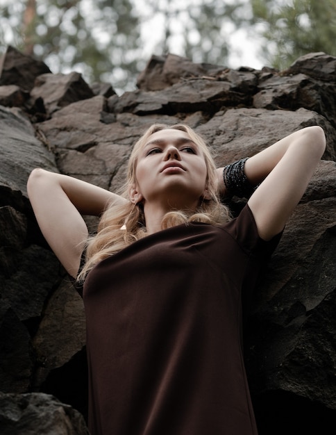 La hermosa chica con un vestido en las rocas