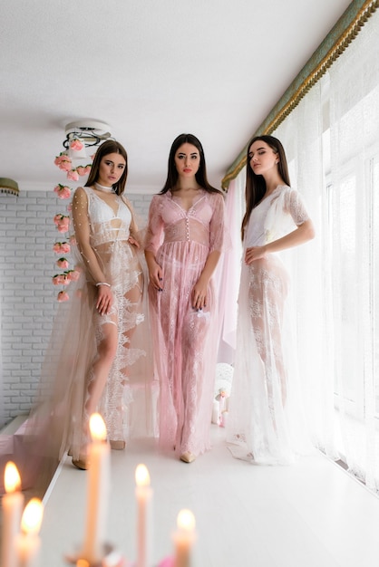 Hermosa chica en vestido de tocador de encaje blanco en la decoración de colores de fondo con ventana grande