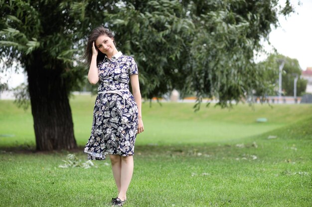 Hermosa chica en vestidos para pasear por el parque