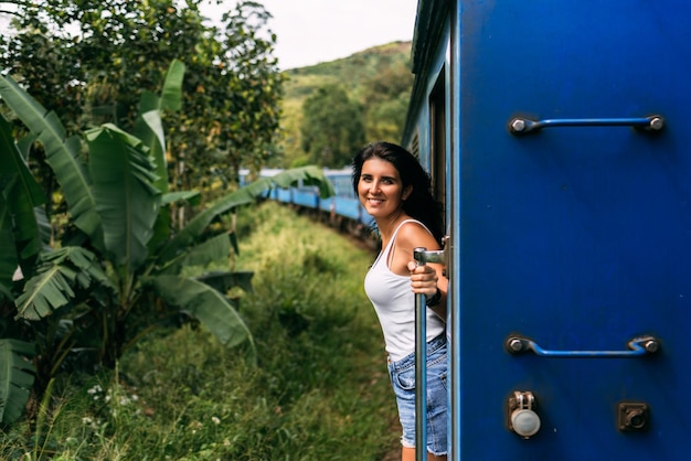 Hermosa chica viajando en tren entre montañas. La niña viaja en tren a lugares hermosos. Viaje en tren. Viajando a Asia. Trenes Sri Lanka. Transporte ferroviario. Ferrocarril. Transporte Asia