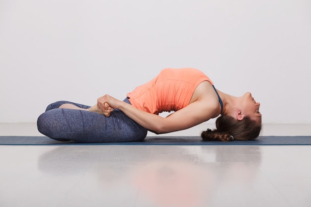 Hermosa chica yogui en forma deportiva practica yoga asana Matsyasana