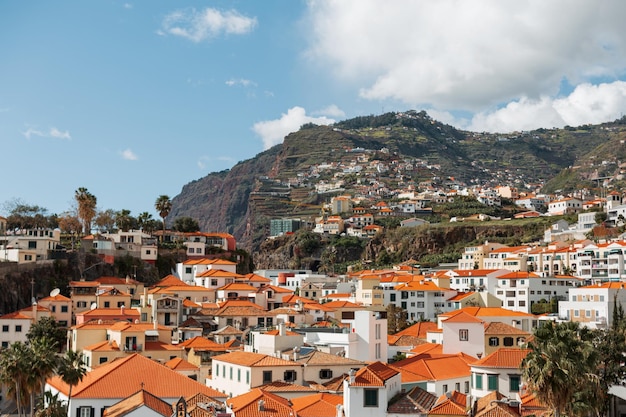 Hermosa ciudad pesquera camara de lobos con casas antiguas y techos naranjas junto al océano con una montaña en la isla de Madeira