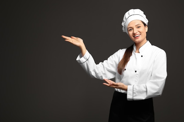 Hermosa cocinera sobre fondo oscuro