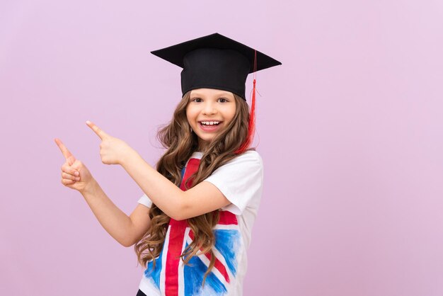 Una hermosa colegiala señala el anuncio y sonríe. La importancia de aprender una lengua extranjera. reglas para aprobar el examen. Cursos de inglés a domicilio.