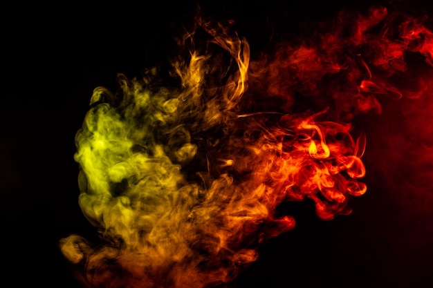 Hermosa columna horizontal de humo en la brillante luz de neón de rojo, verde, amarillo y naranja sobre un fondo negro exhalado del vape Buen patrón para la impresión y el telón de fondo de las ondas de colores