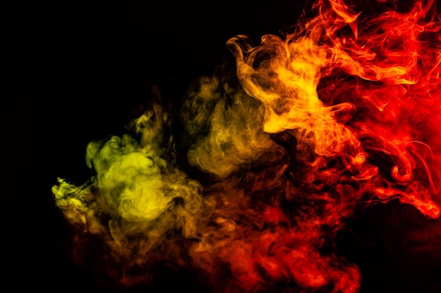 Hermosa columna horizontal de humo en la brillante luz de neón de rojo, verde, amarillo y naranja sobre un fondo negro exhalado del vape Buen patrón para la impresión y el telón de fondo de las ondas de colores