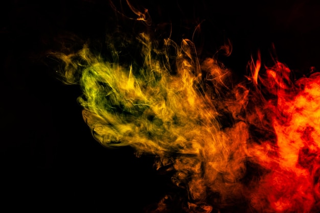 Hermosa columna horizontal de humo en la brillante luz de neón de rojo, verde, amarillo y naranja sobre un fondo negro exhalado del vape Buen patrón para la impresión y el telón de fondo de las ondas de colores