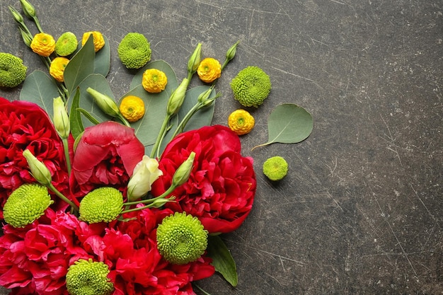 Hermosa composición con flores y hojas sobre fondo gris