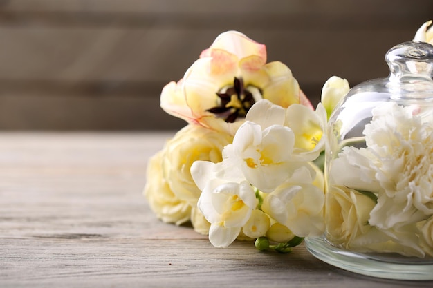 Hermosa composición con flores sobre fondo de madera gris