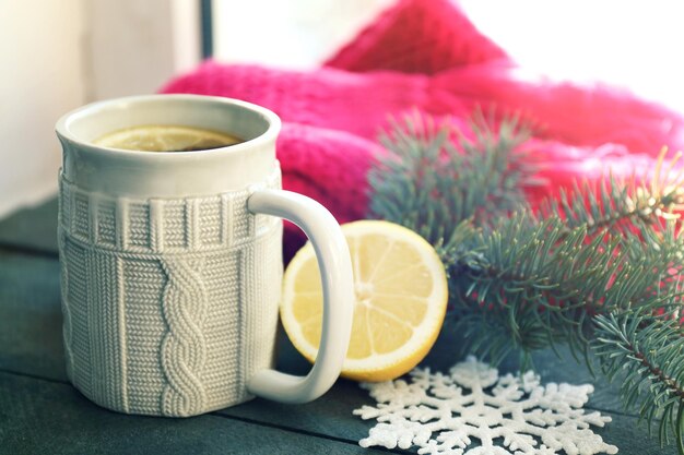 Foto hermosa composición de invierno en el alféizar de la ventana con una taza de bebida caliente