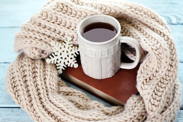 Hermosa composición de invierno con taza de bebida caliente en la mesa de madera