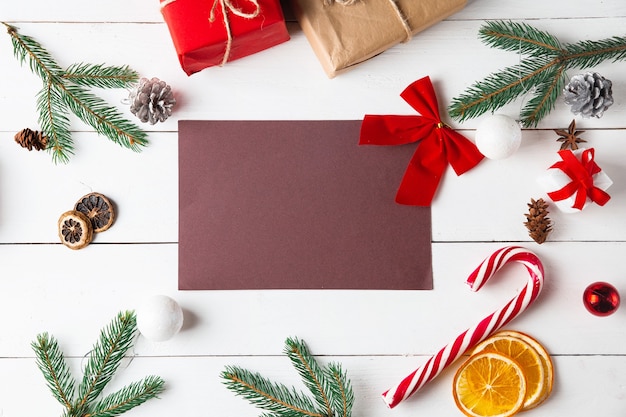 Hermosa composición de Navidad sobre fondo blanco de madera. Tarjeta vacía con cajas de regalo de Navidad