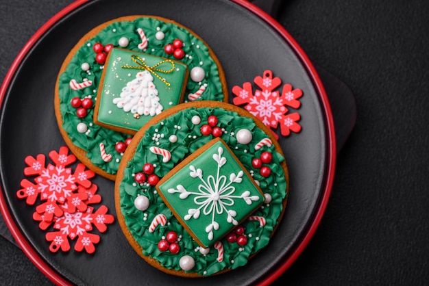 Una hermosa composición navideña que consiste en placas de cerámica, pan de jengibre y otros elementos de decoración de Año Nuevo sobre un fondo de hormigón oscuro