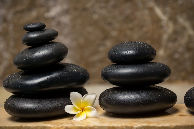 Foto hermosa composición de piedra de spa con flor de frangipani