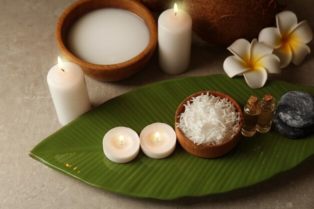 Hermosa composición de spa con productos de cuidado corporal de coco y velas en la mesa