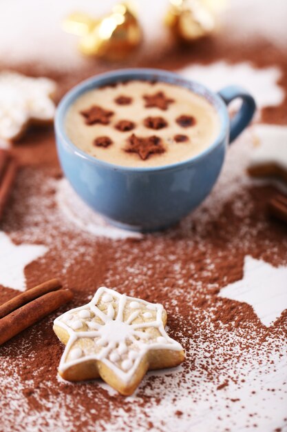 Hermosa composición con taza de capuchino y galletas navideñas