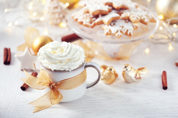 Hermosa composición con taza de capuchino y galletas navideñas