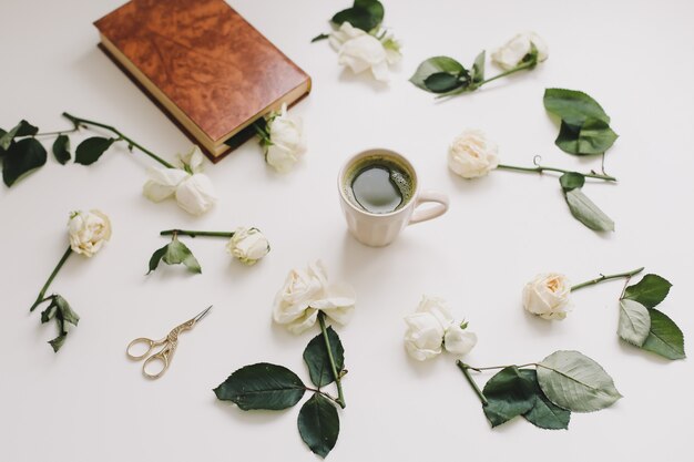 Hermosa composición con taza de té matcha y flores en blanco