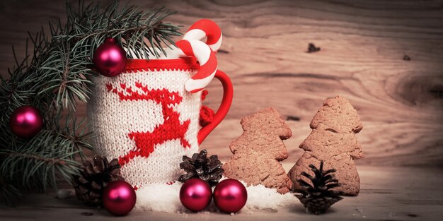 Hermosa Copa de Navidad y hombre de pan de jengibre en la mesa de madera.Foto con espacio para texto