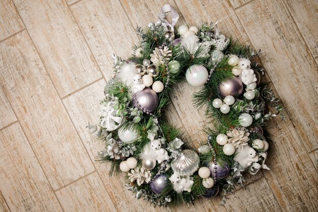 Hermosa corona navideña hecha de abeto y decorada con juguetes