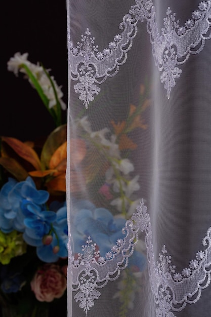 Hermosa cortina de tul o transparente con un patrón sobre un fondo oscuro