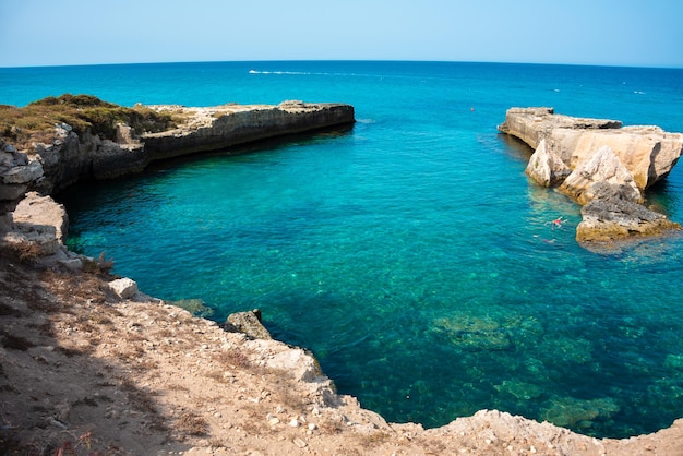 Hermosa costa rocosa en Italia con agua clara y pilas